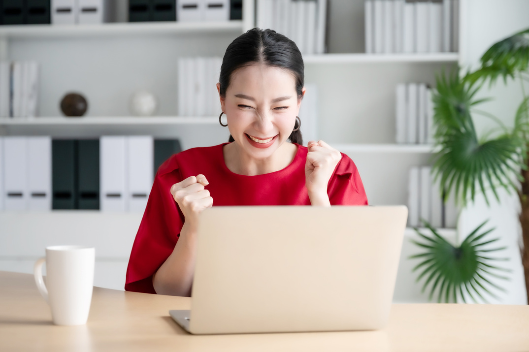 Woman Celebrating and Looking at Laptop 